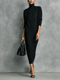 Woman wearing a relaxed turtleneck midi sweater dress with long sleeves