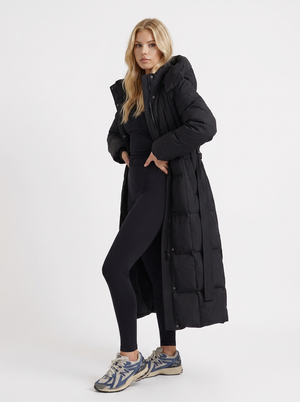Woman wearing a long hooded quilted puffer jacket with tie belt - view 3