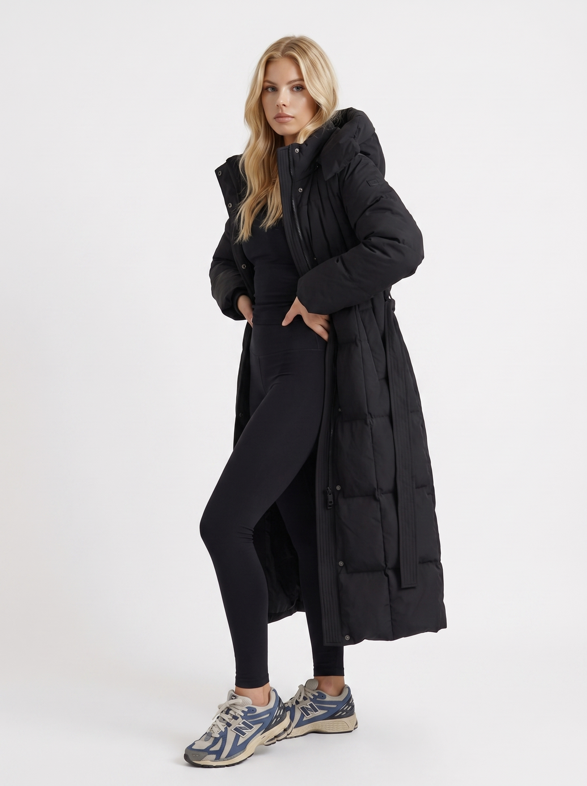 Woman wearing a long hooded quilted puffer jacket with tie belt - view 3