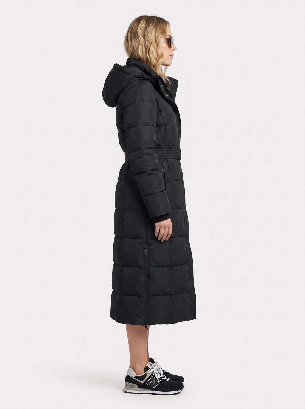 Woman wearing a long hooded quilted puffer jacket with tie belt - view 4