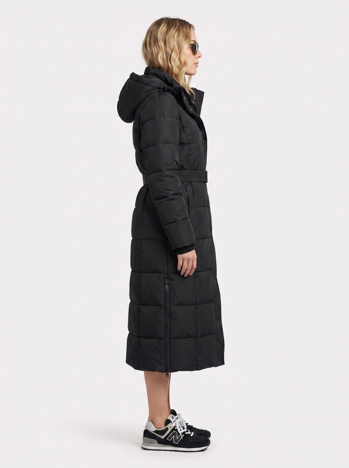 Woman wearing a long hooded quilted puffer jacket with tie belt - view 4
