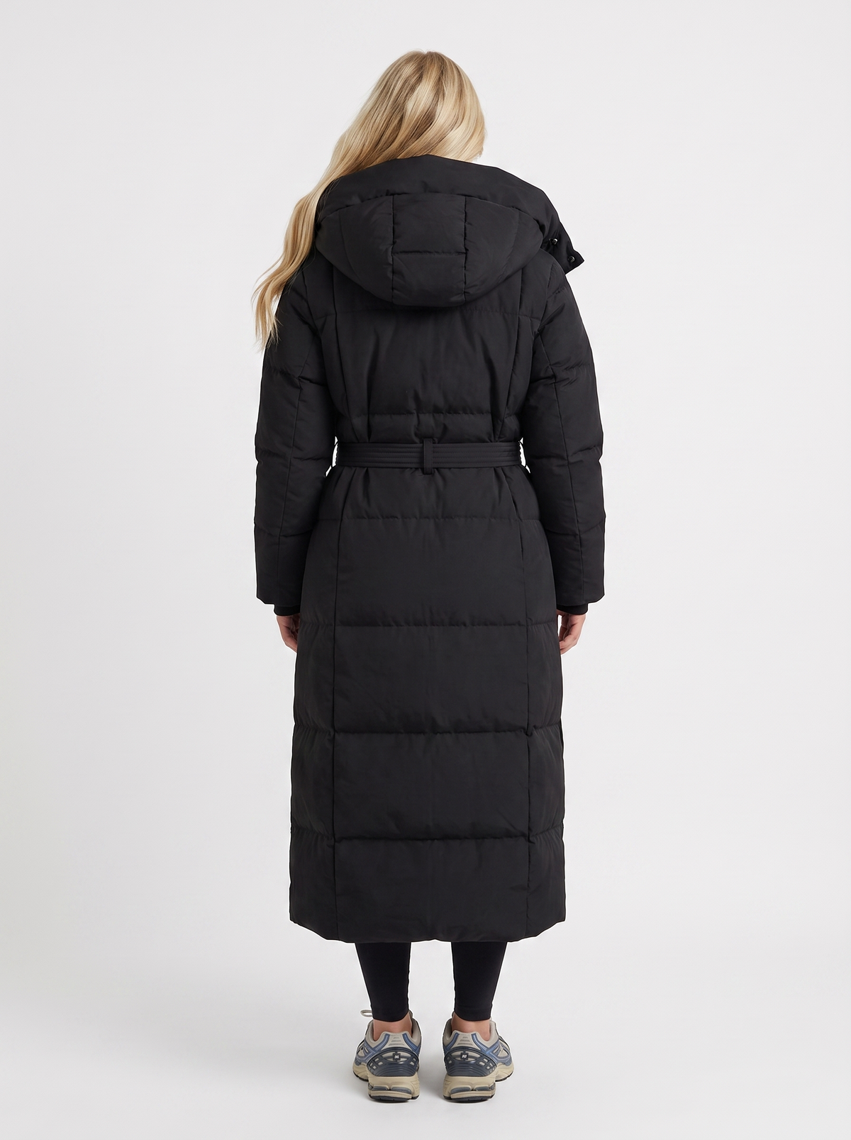 Woman wearing a long hooded quilted puffer jacket with tie belt - view 5