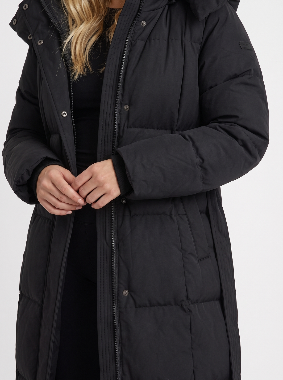 Woman wearing a long hooded quilted puffer jacket with tie belt - view 6