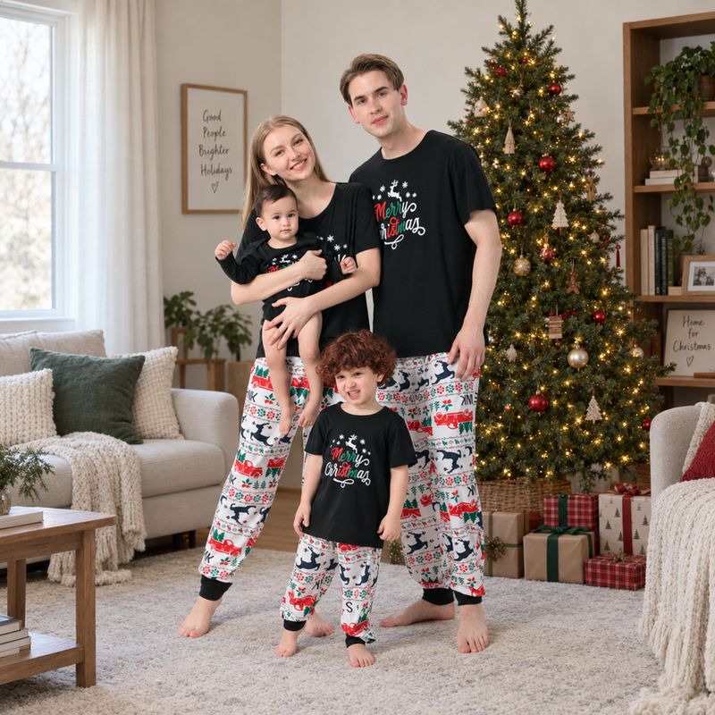 Whole family in black Merry Christmas tees and festive print jogger pajamas beside a Christmas tree