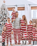 Family wearing matching red and white striped Christmas pajamas with gray cuffs