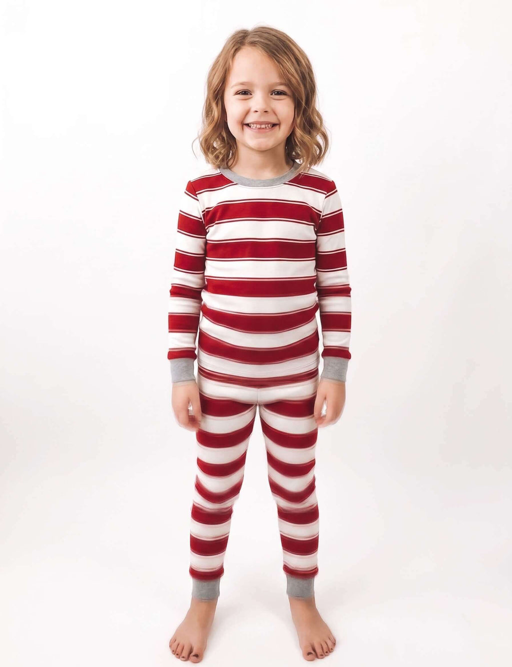 Family wearing matching red and cream striped Christmas pajamas with gray cuffs - view 11