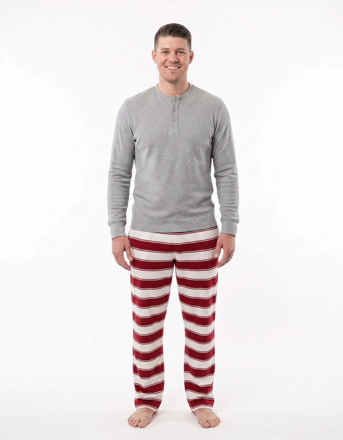 Family wearing matching red and cream striped Christmas pajamas with gray cuffs - view 8