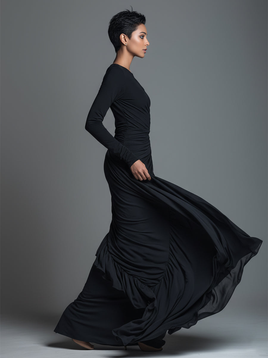 Woman wearing a black long sleeve ruched maxi dress with a draped skirt - view 5