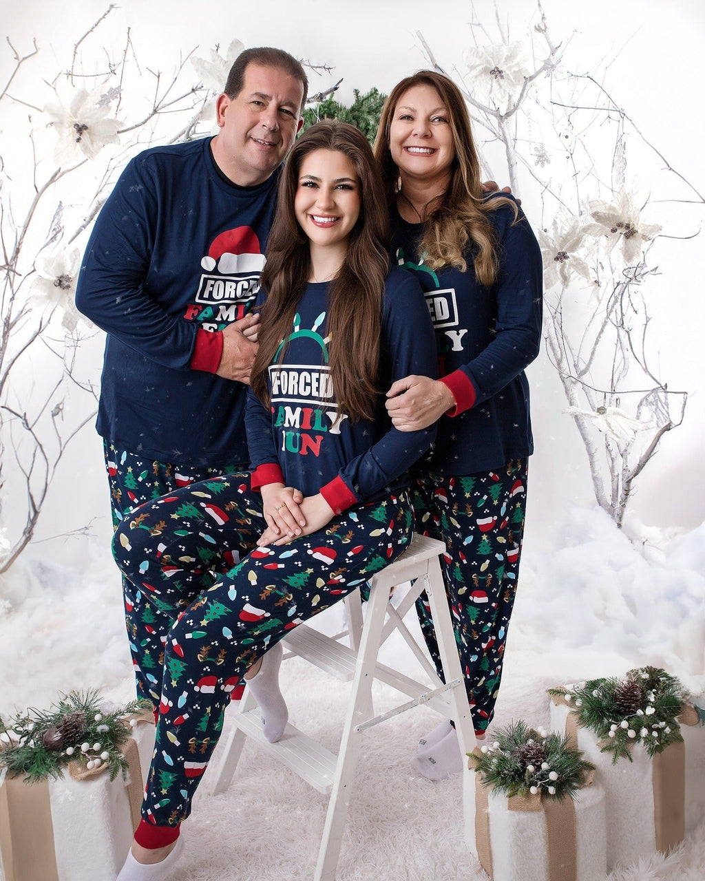 Family wearing matching navy Christmas pajamas with Santa hat graphic tops and holiday print pants - view 5