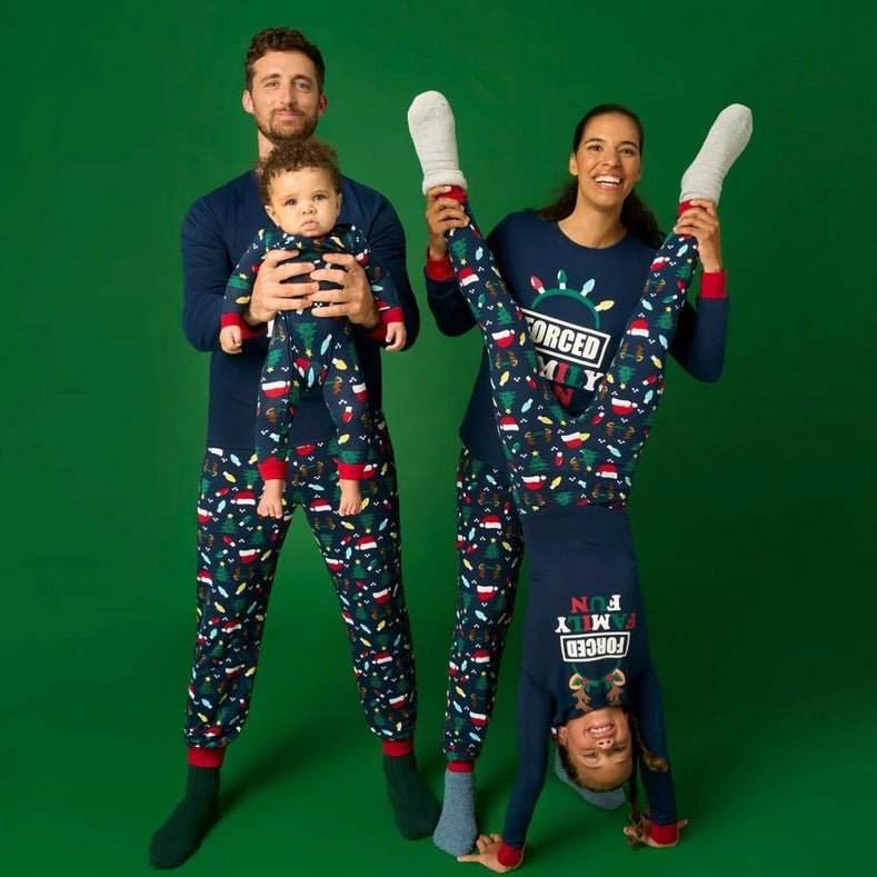 Family wearing matching navy Christmas pajamas with Santa hat graphic tops and holiday print pants - view 8