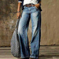 Woman wearing relaxed faded wide leg jeans with a belt and white tee