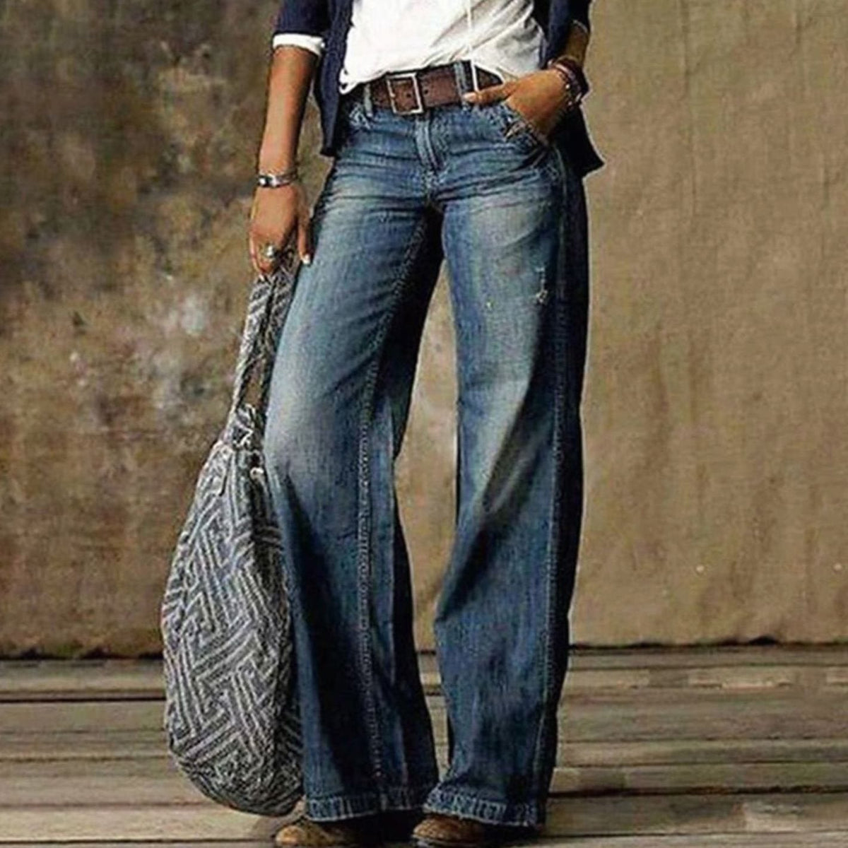 Woman wearing relaxed faded wide leg jeans with a belt and white tee - view 2