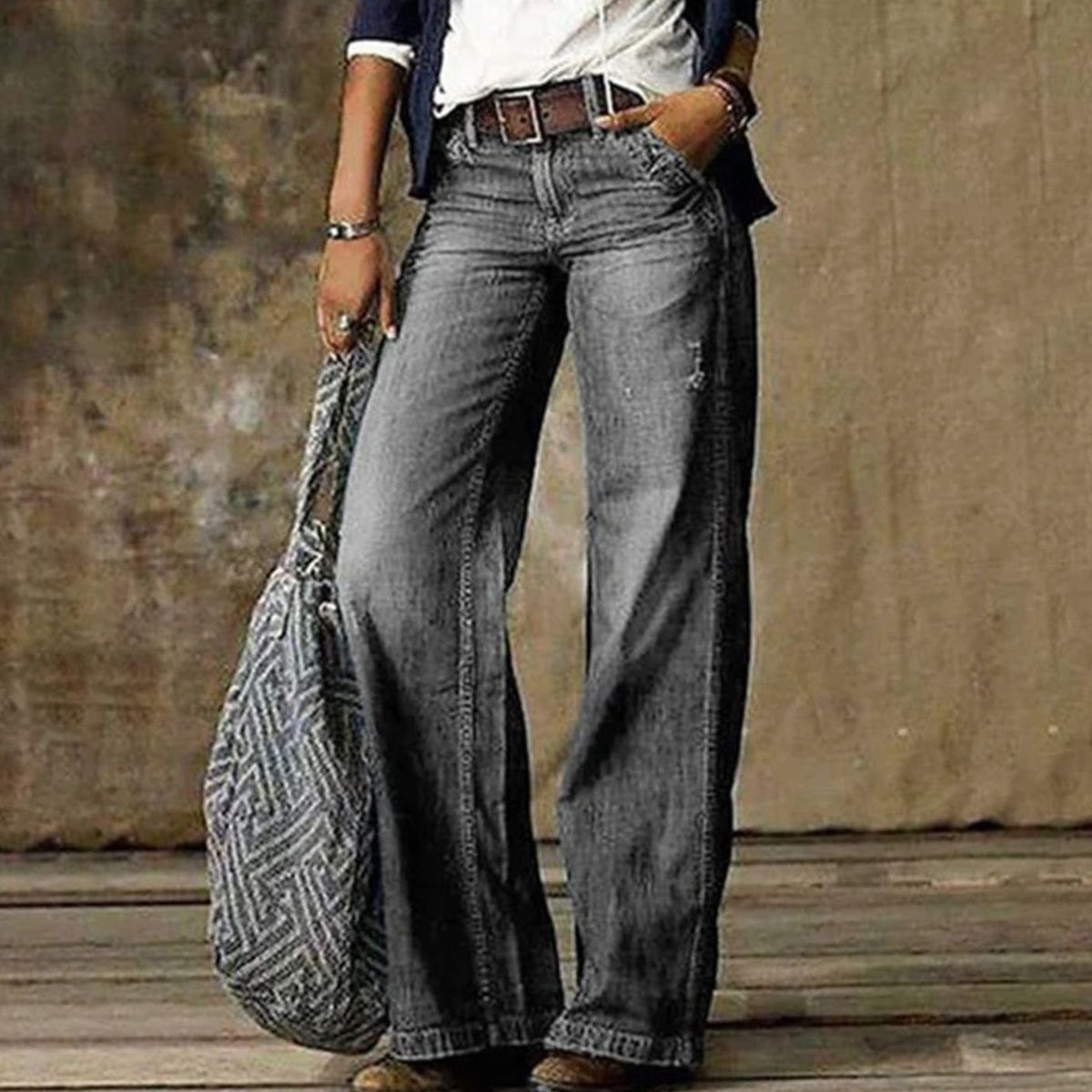 Woman wearing relaxed faded wide leg jeans with a belt and white tee - view 3
