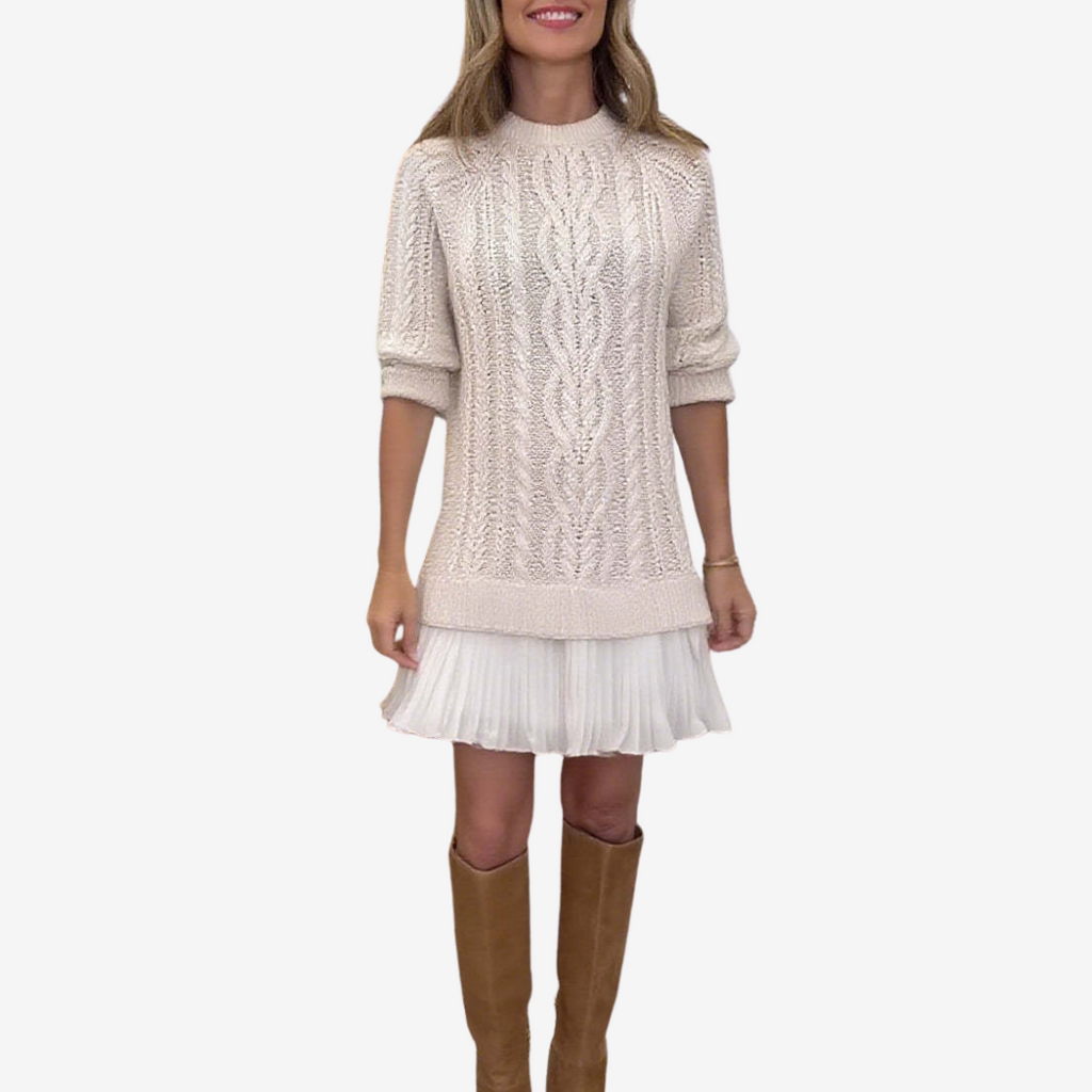 Woman wearing a cable knit sweater dress with a white pleated hem and brown knee-high boots - view 3