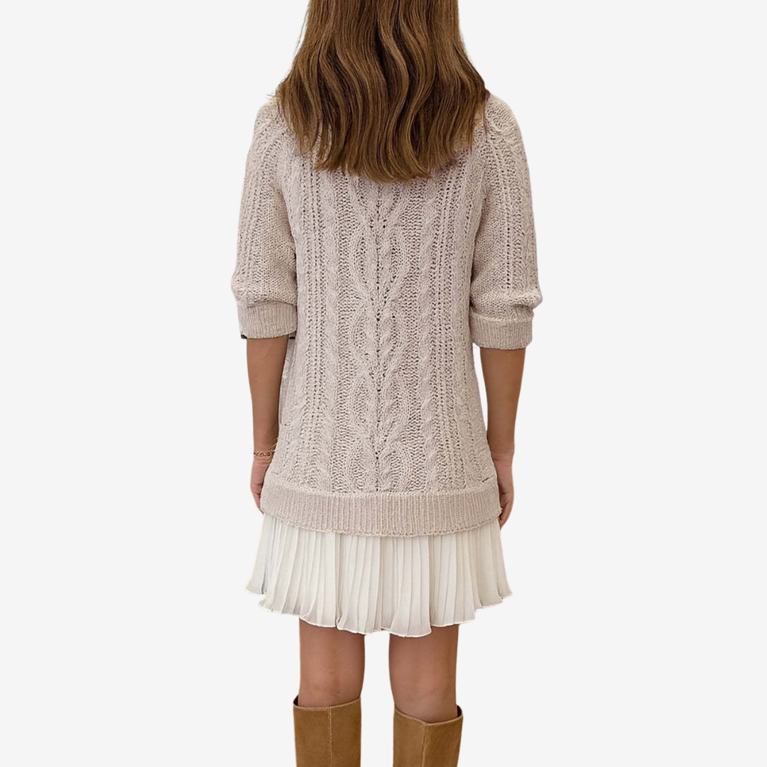 Woman wearing a cable knit sweater dress with a white pleated hem and brown knee-high boots - view 4