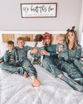Family wearing matching green jungle animal print Christmas pajamas