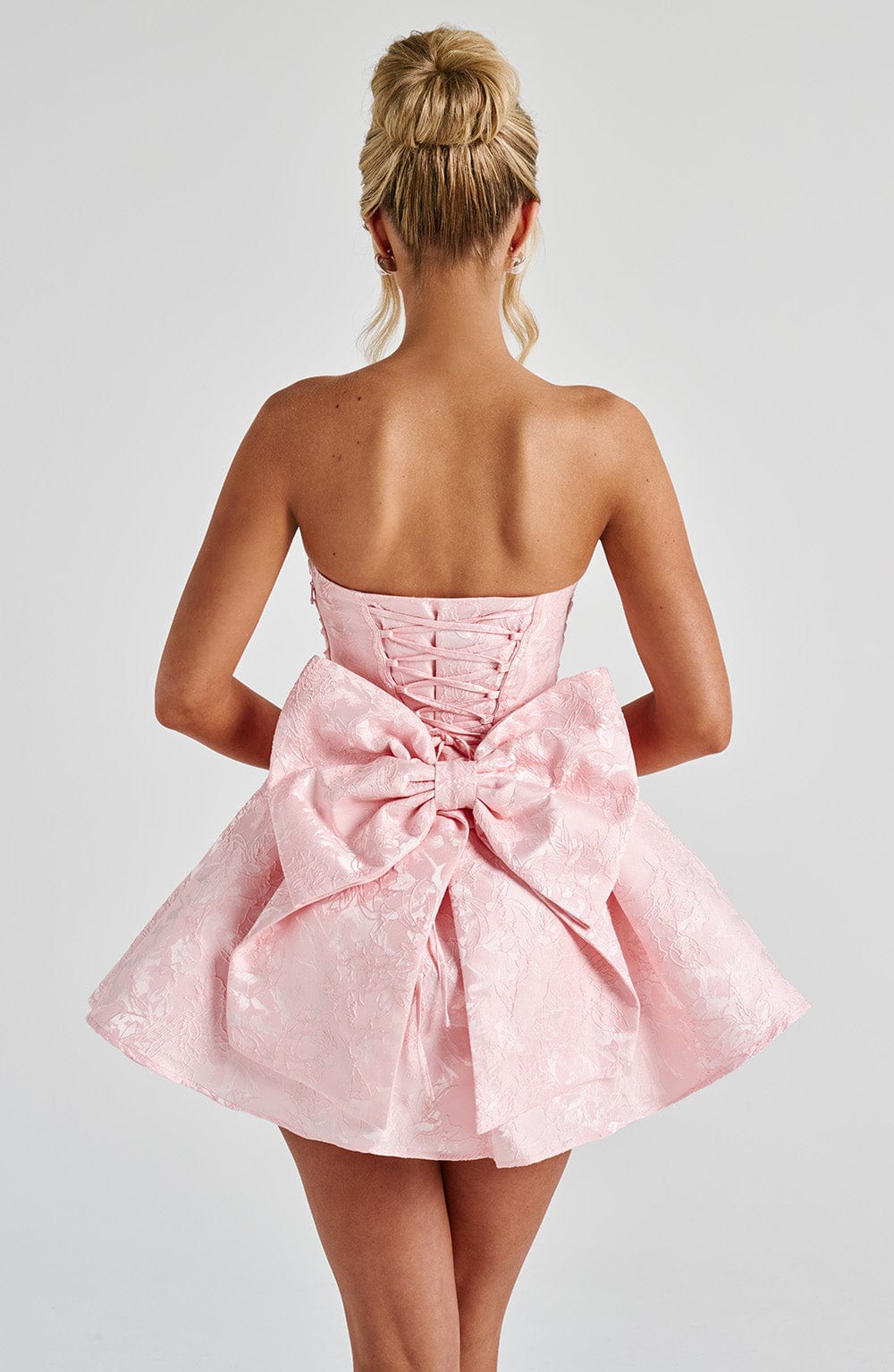 Pink jacquard homecoming mini dress with strapless bodice, corset lacing and large back bow - view 3