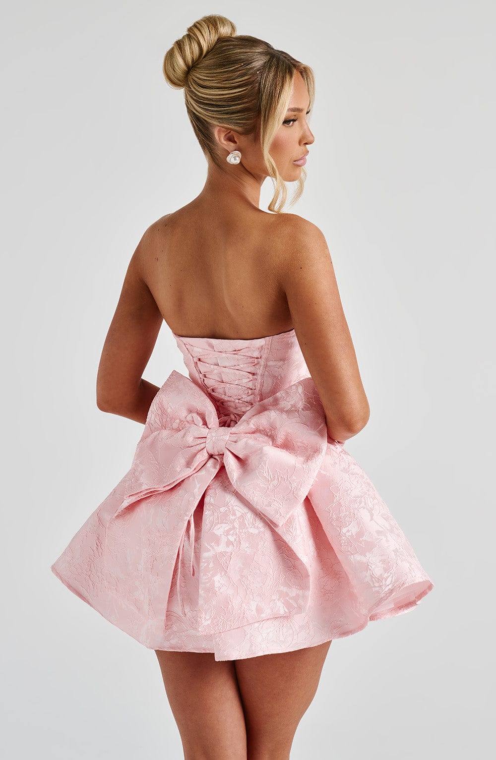 Pink jacquard homecoming mini dress with strapless bodice, corset lacing and large back bow - view 7