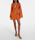 Long sleeve sequin mini dress with flared sleeves and gold-tone ring at deep V-neck
